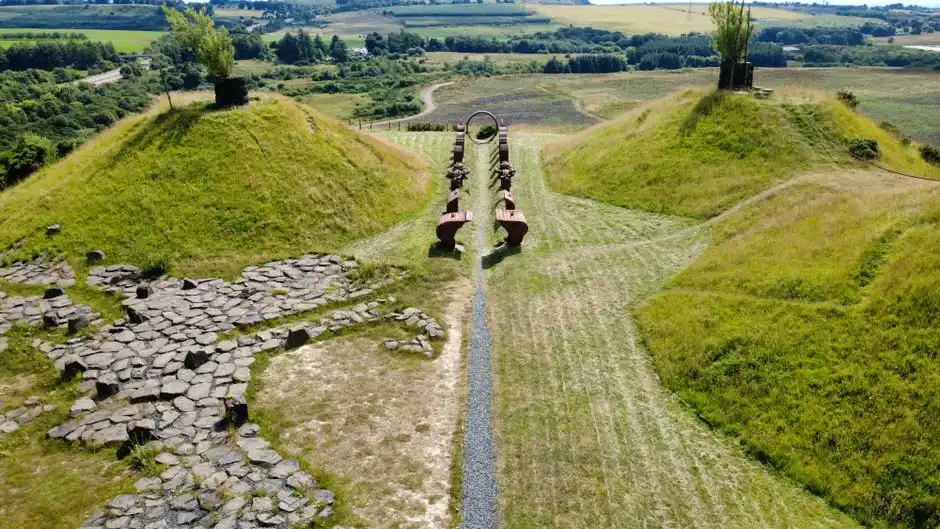 A stunning aerial view of The Kelpies Sculpture Park, showcasing lush green hills and artistic landscapes in Scotland.